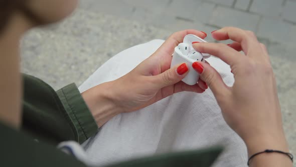 Woman Open Charging Box with Wireless Earbuds