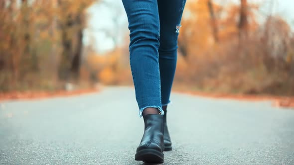 Woman Legs Walking. Woman Feet Walking On Road. Girl In Leather Shoes Sneakers Relaxing At Fall