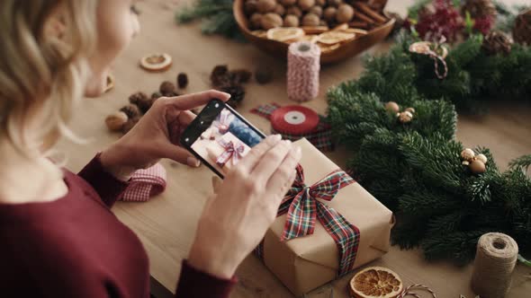 Blonde woman packing Christmas present. Shot with RED helium camera in 8K