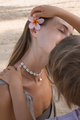 Child decorating mother's hair by flower at sea beach in sunny summer day - PhotoDune Item for Sale