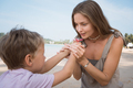Little child gives mother flower at beach in sunny summer day - PhotoDune Item for Sale