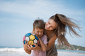 Beautiful young mother and son playing ball at beach in sunny day and hugging - PhotoDune Item for Sale