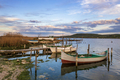 The tranquil afternoon on a lake with a wooden pier and boats in the colorful sky. - PhotoDune Item for Sale