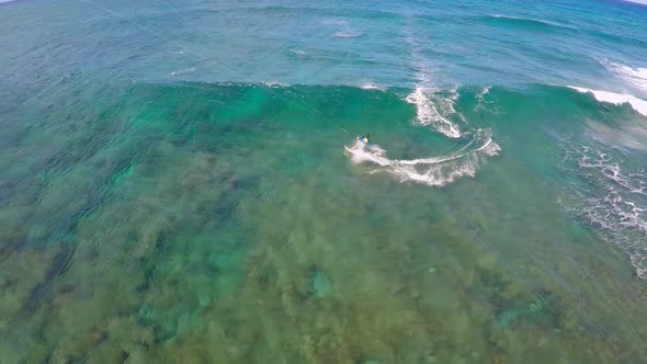 Aerial view of a man kitesurfing in Hawaii.