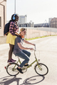 Young couple riding bicycle with girl standing on rack - PhotoDune Item for Sale