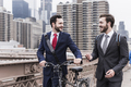 USA, New York City, two businessmen with bicycle on Brooklyn Bridge - PhotoDune Item for Sale