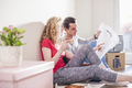 Young couple in new home sitting on floor discussing ground plan - PhotoDune Item for Sale