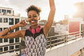 Portrait of happy young woman with headphones on rooftop - PhotoDune Item for Sale