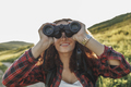 Teenage girl with backpack using binoculars in nature - PhotoDune Item for Sale