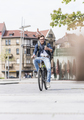 Smiling young man with bicycle in the city looking at cell phone - PhotoDune Item for Sale