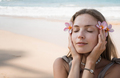 Face portrait of beautiful blond woman holding flowers close to face at beach - PhotoDune Item for Sale