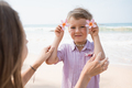 Little boy holding exotic flowers with mother at beach in sunny summer day - PhotoDune Item for Sale