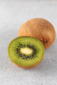 Green ripe kiwi half and whole on grey table. Place for text. Horizontal photo. - PhotoDune Item for Sale