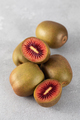 Red kiwi whole and halves on the table. Tropical fruit concept, kiwi variety. - PhotoDune Item for Sale