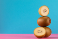 Still life of balancing golden kiwis on a blue background. The concept of fruits. Copy space - PhotoDune Item for Sale