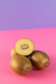 Golden kiwis whole and cut in half on a colored background. Tropical fruits. - PhotoDune Item for Sale