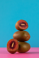 Still life of balancing red kiwis on a blue background. The concept of fruits - PhotoDune Item for Sale