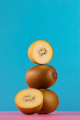 Still life of balancing golden kiwis on a blue background. The concept of fruits - PhotoDune Item for Sale