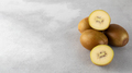 Golden yellow kiwi whole and halves on a gray background. Fruit concept - PhotoDune Item for Sale