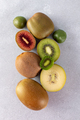 Different varieties of kiwi lie in a pile on the table. Halves of red, yellow, green kiwi - PhotoDune Item for Sale