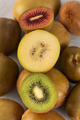 Different varieties of kiwi lie in a pile on the table. Halves of red, yellow and green kiwi. - PhotoDune Item for Sale