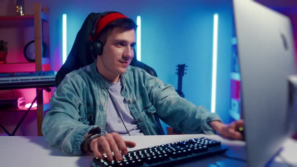 Young Hipster Man Playing Online Computer Video Game Colorful Lighting Broadcast Streaming Live Home