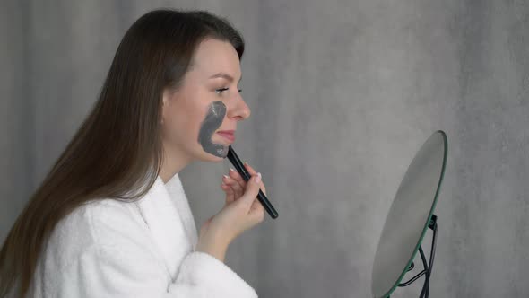 Young Woman Takes Care of Skin of Face