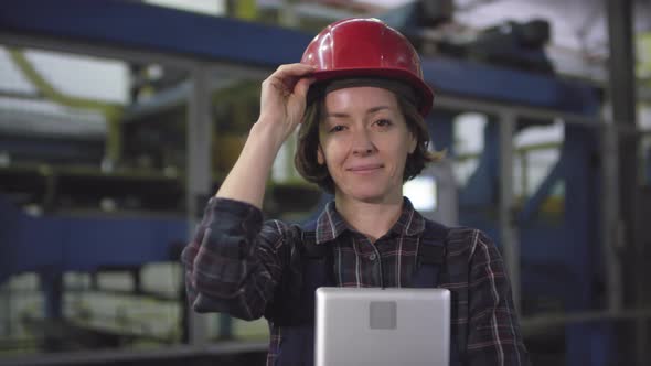 Smiling Female Engineer Posing in front of Automated Production Line at Factory