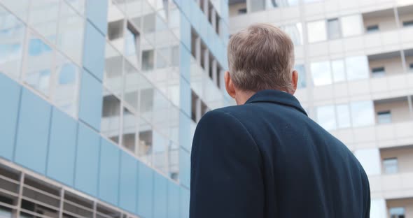 Low Angle View of Mature Businessman Standing Outside Office Building