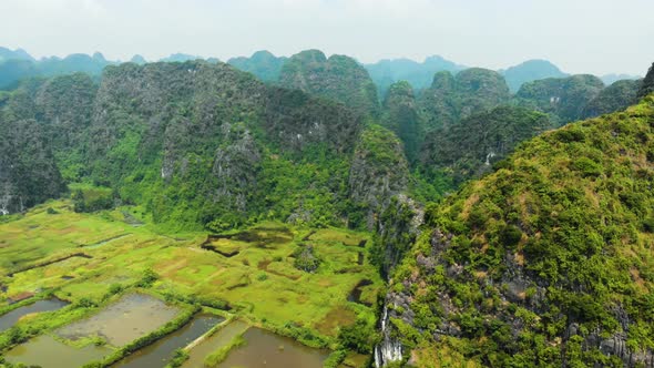 Aerial: North Vietnam karst landscape at sunset, drone view of Ninh Binh region, tourist destination