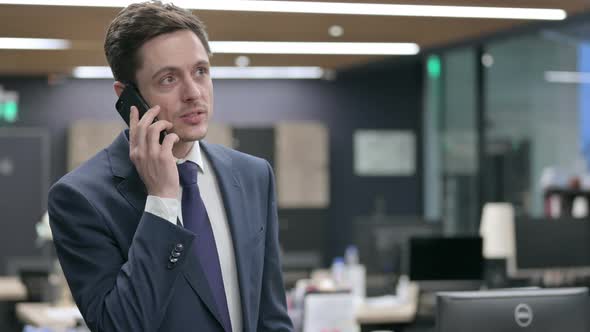 Businessman Talking on Smartphone in Office