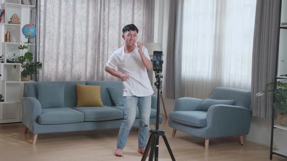 Asian Boy Dancing While Shooting Video Content For Social Networks With A Smartphone Camera