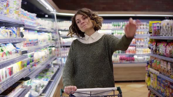 At the Supermarket Happy Young Woman Dances Through Goods and Dairy Products on the Shelves