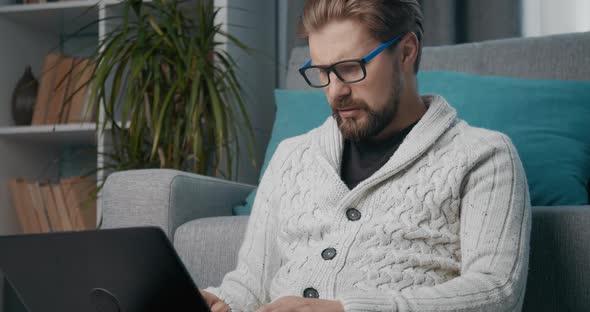 Businessman Sitting at Home and Working on Laptop