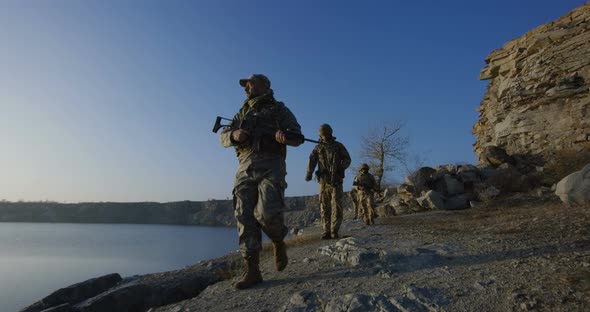 Armed Soldiers Walking By a Lake alt