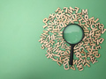 Wooden word and magnifying glass on a green background - PhotoDune Item for Sale