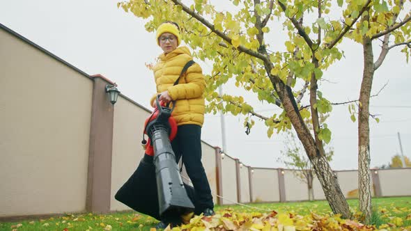 Cute Boy in Yellow Beanie and Jacket Helping Parents at Backyard on Autumn Day