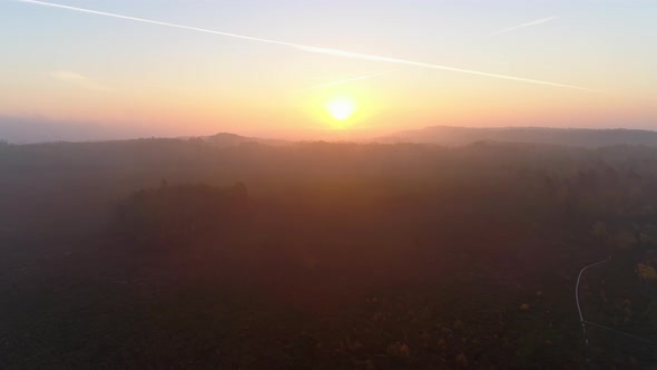 Aerial View of Sunrise Over Foggy Landscape