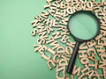 Wooden word and magnifying glass on a green background - PhotoDune Item for Sale