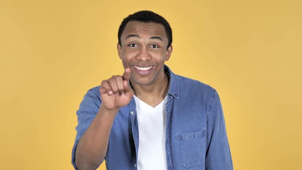 Young African Man Pointing at Camera Yellow Background