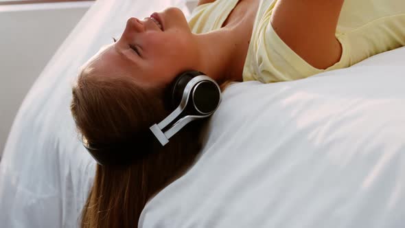 Teenage girl listening music while using mobile phone