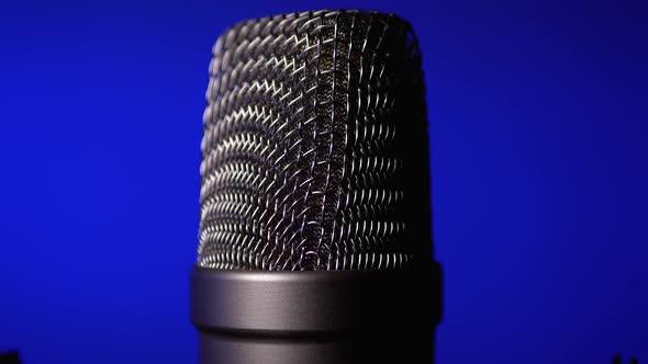 Studio Condenser Microphone Rotates on Blue Background.