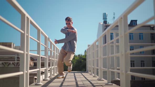 Stylish Caucasian Man in Sunglasses Street Dancer Dancing Break Dance on the Background City Street