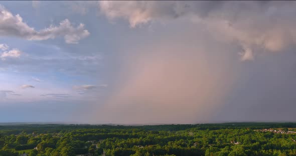 Bright Rainbow in the Sky During a Severe Thunderstorm Against Landscape