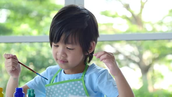 Cute Asian Boy Painting A Picture