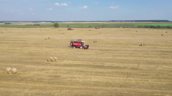 Agricultural Combines Harvest Ripe Wheat Crops On Rural Field Aerial Side View