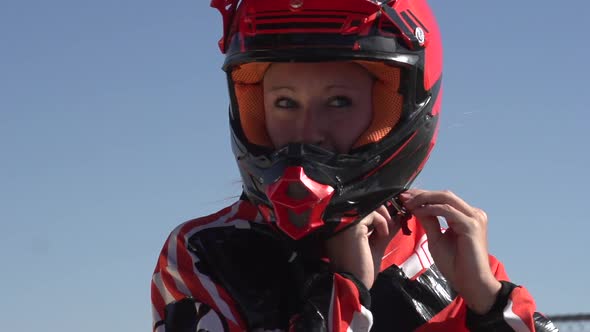 A young woman bmx rider putting on helmet.