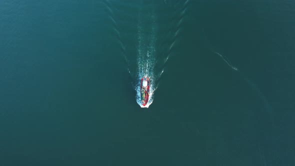 Drone flying over a fishing boat that is sailing on the sea