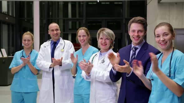 Team of doctors and businessman applauding during meeting