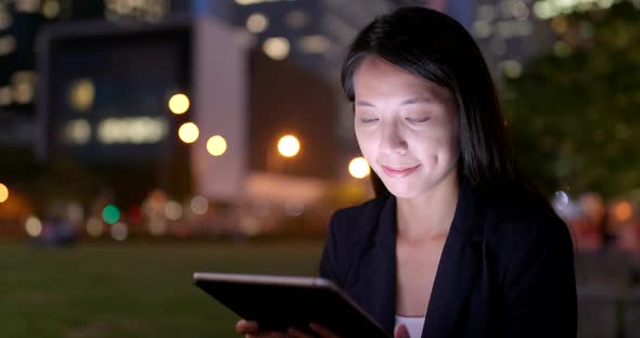 Business woman use of tablet computer at night